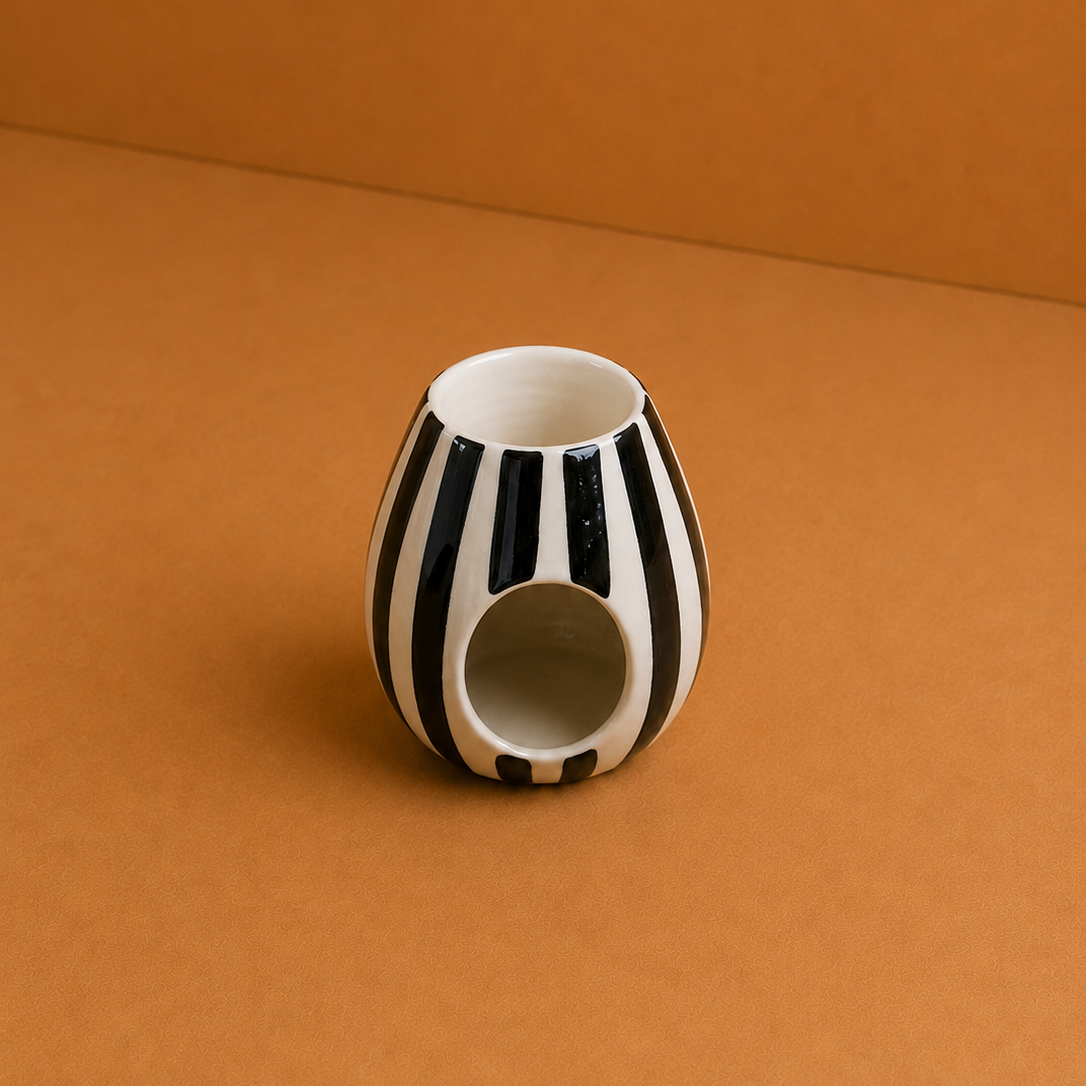 Ceramic vase with black and white stripes on a brown background